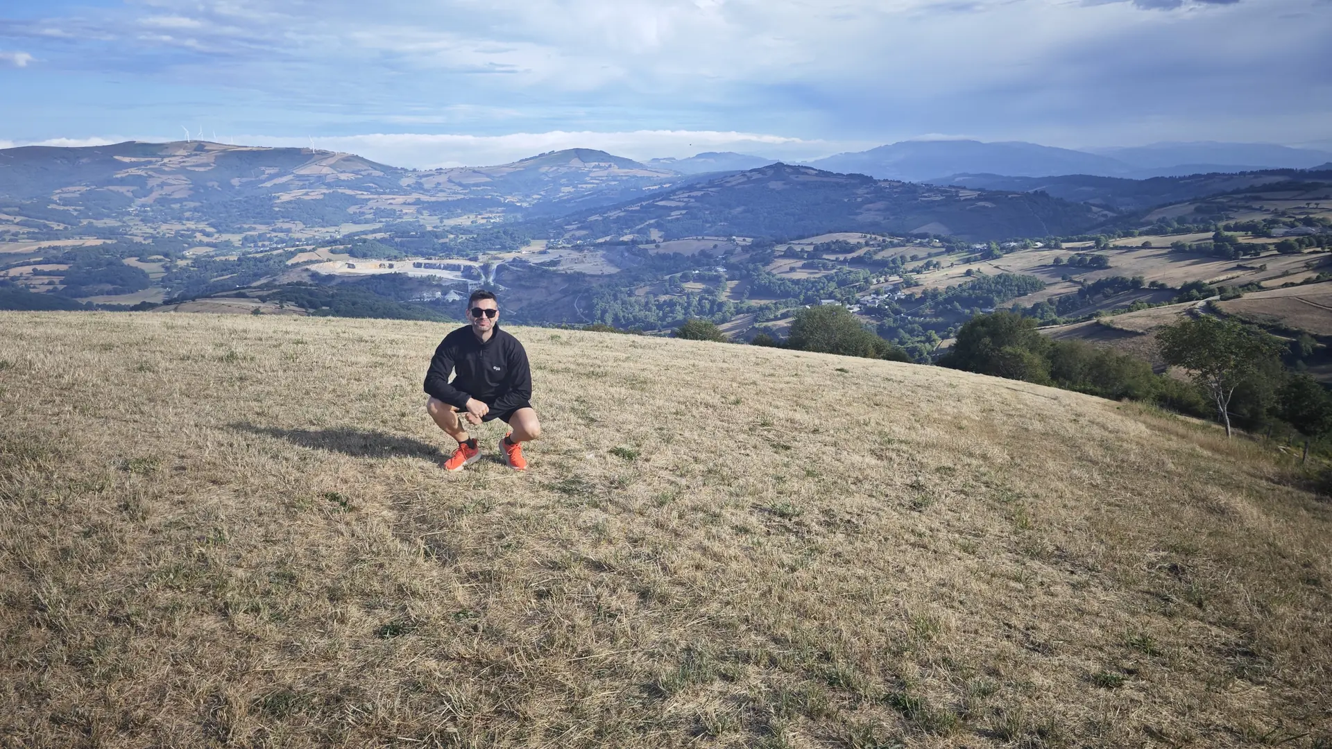 José, agachado en lo alto de un monte, con el valle detrás