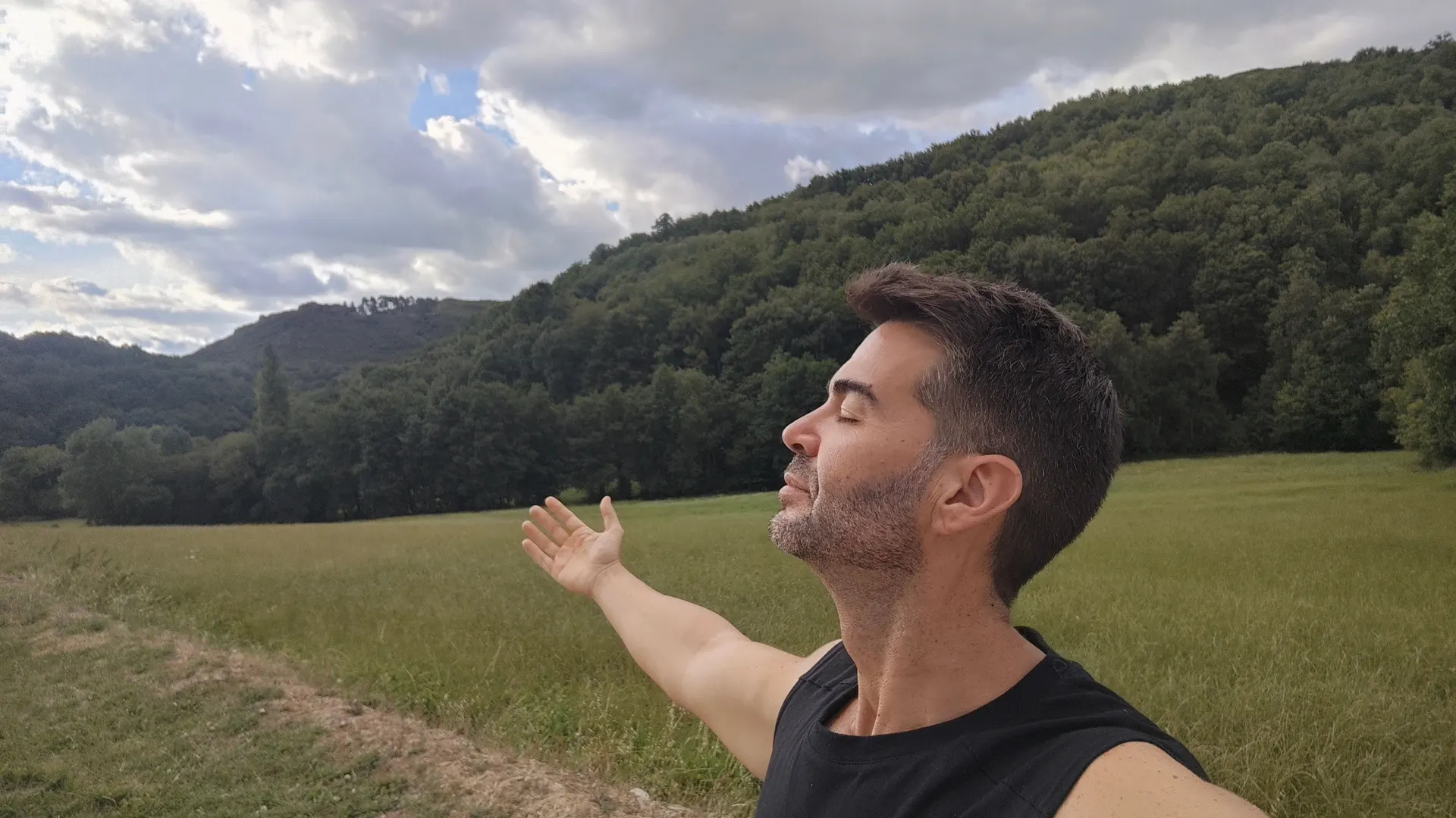 José, con los ojos cerrados y un brazo abierto, en un prado junto al bosque